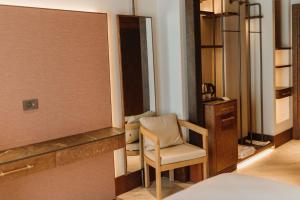 a bedroom with a chair and a mirror at The Noria Hotel in Arsuz +7 photos