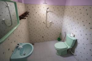 a bathroom with a green toilet and a sink at East Breeze in Arugam Bay