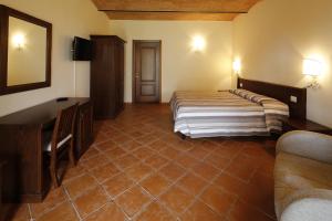 a hotel room with two beds and a television at Agriturismo Poggio Al Tufo in Pitigliano