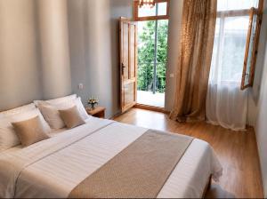 a bedroom with a large bed and a large window at Andranik B&B in Goris