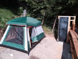 a green tent next to a door in a field at Tente tout confort in Sarrancolin