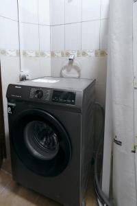 a washing machine in a corner of a room at Hewani a bright & airy 1 BR apartment with an ocean view & pool in Kilifi
