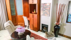 a living room with a table and a fireplace at Edenbrook Country Manor in Plettenberg Bay