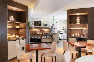 a kitchen with two tables and chairs and a counter at Hotel Parigi 2 & Spa in Dalmine