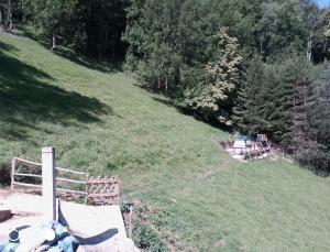 a grassy hill with a wooden fence in a field at Tente tout confort in Sarrancolin
