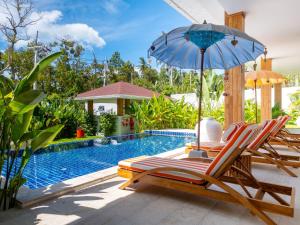 a couple of chairs and an umbrella next to a swimming pool at Enchanting Villa Namaste 3Br Private Pool & Garden in Nathon Bay