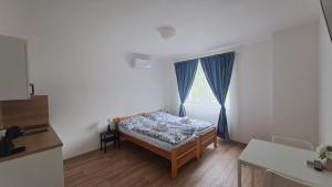 a small bedroom with a bed and a window at Valen apartmány Valtice in Valtice