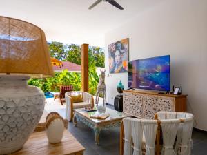a living room with a tv and a table and chairs at Enchanting Villa Namaste 3Br Private Pool & Garden in Nathon Bay