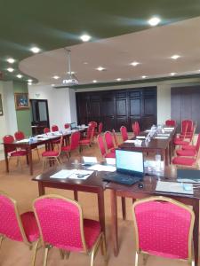 a conference room with tables and chairs and a laptop at Hotel Valea cu Pesti in Căpăţîneni-Ungureni +66 photos