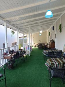 a room with chairs and tables and green carpet at Casa Chriss in Eforie Sud