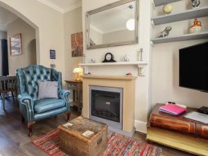 a living room with a chair and a fireplace at Pankhurst Cottage in Louth