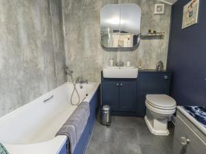 a bathroom with a tub and a toilet and a sink at Pankhurst Cottage in Louth +22 photos