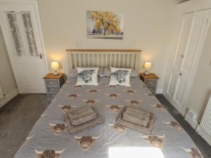 a bedroom with a bed with cats on it at Pankhurst Cottage in Louth