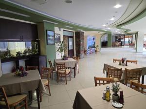 a dining room with tables and chairs in a restaurant at Hotel Valea cu Pesti in Căpăţîneni-Ungureni