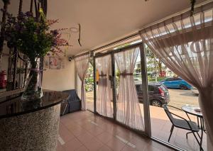 a room with sliding glass doors with a table and chairs at Wangsa Village Inn in Ulu Tiram