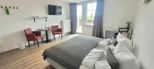 a bedroom with a bed and a table and chairs at Hotel Rosenhof - Braunlage in Braunlage