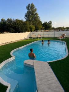 a group of three men in a swimming pool at La Ferme de la Maugerie in Thoury
