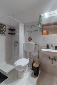 a white bathroom with a toilet and a sink at Beachside Apartment-2 in Afantou +41 photos