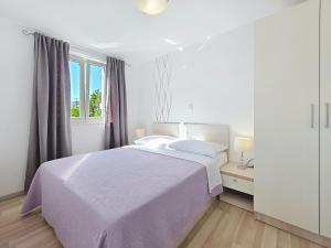 a white bedroom with a bed and a window at Apartments Gorica 2 in Baška +192 photos