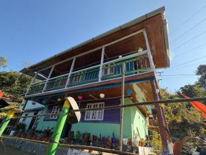 a house with a balcony on the side of it at Karki Farm Stay in Bijanbāri Bāzār
