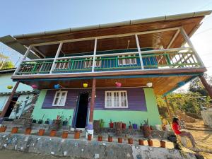 a woman standing in front of a house at Karki Farm Stay in Bijanbāri Bāzār