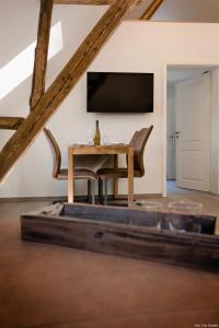 a living room with a table and a television at Haus Auf der Zinn in Beilstein