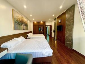 a large bedroom with two beds and a blue chair at NBZ Homestay in Hanoi +26 photos
