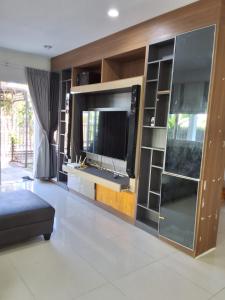a living room with a large entertainment center with a flat screen tv at The Plant Light Thiwanon in Lat Lum Kaeo