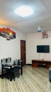 a dining room with a table and a television at Varine House in Dodoma