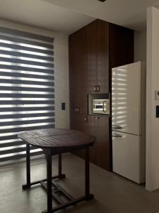 eine Küche mit einem Holztisch und einem Kühlschrank in der Unterkunft Merichas Luxurious Villa in Kythnos + 6 Fotos
