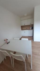 a white table and chairs in a room with a kitchen at Valen apartmány Valtice in Valtice +26 photos
