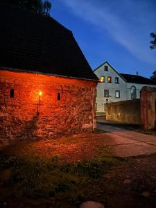 a brick building with a light on it at night at Rittergut Hohenfichte Herrenhaus in Leubsdorf