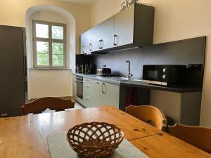 a kitchen with a wooden table with chairs and a tableasteryasteryasteryasteryastery at Rittergut Hohenfichte Herrenhaus in Leubsdorf