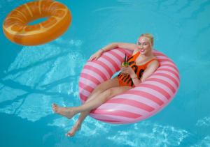 a woman is sitting on an inflatable at Hotel Magnólia in Piešťany