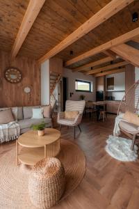 a living room with a couch and a table at Sploty Lasu u stóp Lubonia - Domki z Jacuzzi in Rabka-Zdrój