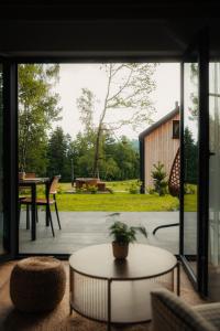 a living room with a view of a patio at Sploty Lasu u stóp Lubonia - Domki z Jacuzzi in Rabka-Zdrój