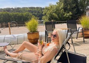 a woman sitting in a chair with a drink at Hotel Magnólia in Piešťany