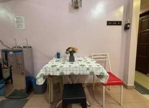 a table with a vase of flowers on it at Wangsa Village Inn in Ulu Tiram