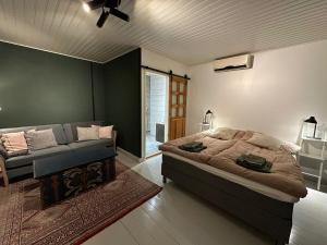 ein Schlafzimmer mit einem Bett und einer Couch in der Unterkunft Matmalmen E&A in Pargas
