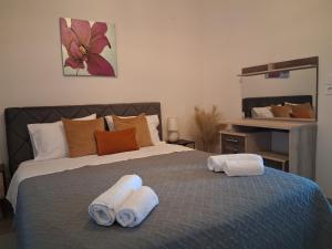 a bedroom with a bed with towels on it at Katrin chios in Chios