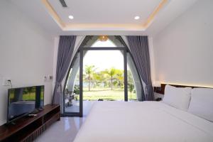 a bedroom with a large bed and a large window at Blue Haven Resort Quy Nhơn in Quy Nhon