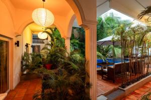 an indoor courtyard with a table and chairs and palm trees at Samaya Boutique & Cuisine in Phnom Penh
