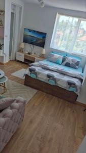 a bedroom with a large bed and a large window at DIV Apartman in Vrnjci