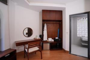 a bathroom with a desk and a mirror and a sink at Blue Haven Resort Quy Nhơn in Quy Nhon +162 photos