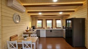 a kitchen with a table and a black refrigerator at The Heart Cabin בקתת הלב in Kidmat Tsvi