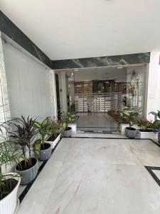 a lobby with potted plants on the floor of a building at Lucknow Courtyard in Lucknow