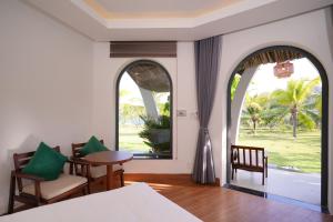 a bedroom with a bed and a table and chairs at Blue Haven Resort Quy Nhơn in Quy Nhon