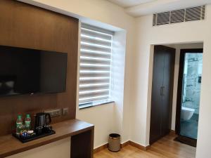 a living room with a flat screen tv on a wall at L G Cordial in Mysore