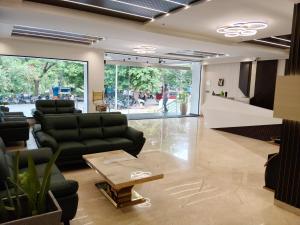 a lobby with couches and a table in a room at L G Cordial in Mysore