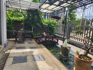 a conservatory with a pond and tables and plants at The Plant Light Thiwanon in Lat Lum Kaeo